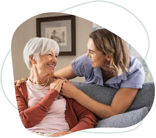 A Goldy Enrichment Specialist smiling warmly with an older woman at home