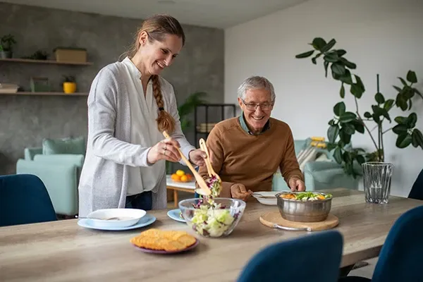 A Goldy Enrichment Specialist preparing a home-cooked meal with an older client