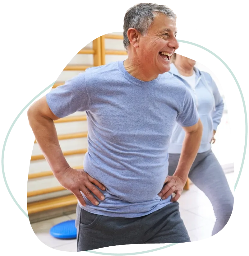 A smiling older man stretching during a workout