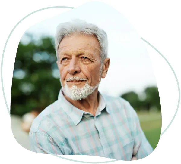 An older man looking thoughtfully into the distance outdoors