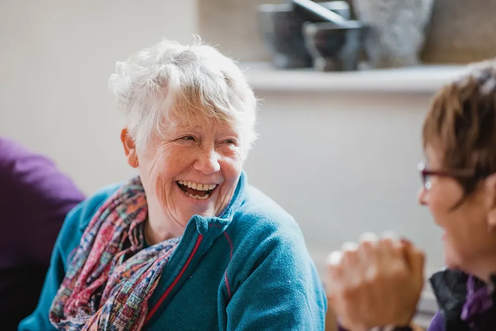 A happy older woman smiling alongside a companion